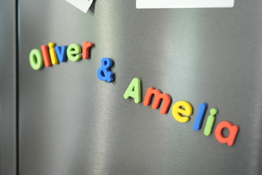 Colourful fridge magnets in the shape of letters spell out: Oliver & Amelia