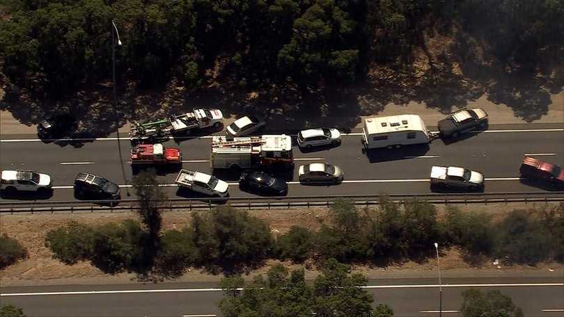 Drivers are stuck in their vehicles with the bushfire closing the road.
