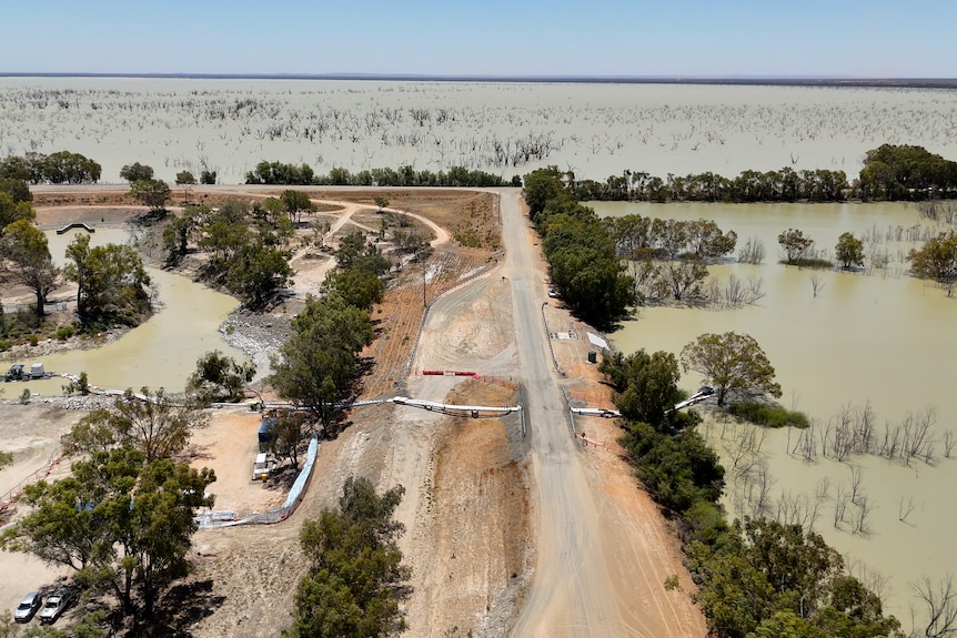 A photo of a pipe running over a dirt road at the Menindee Lakes in outback NSW.