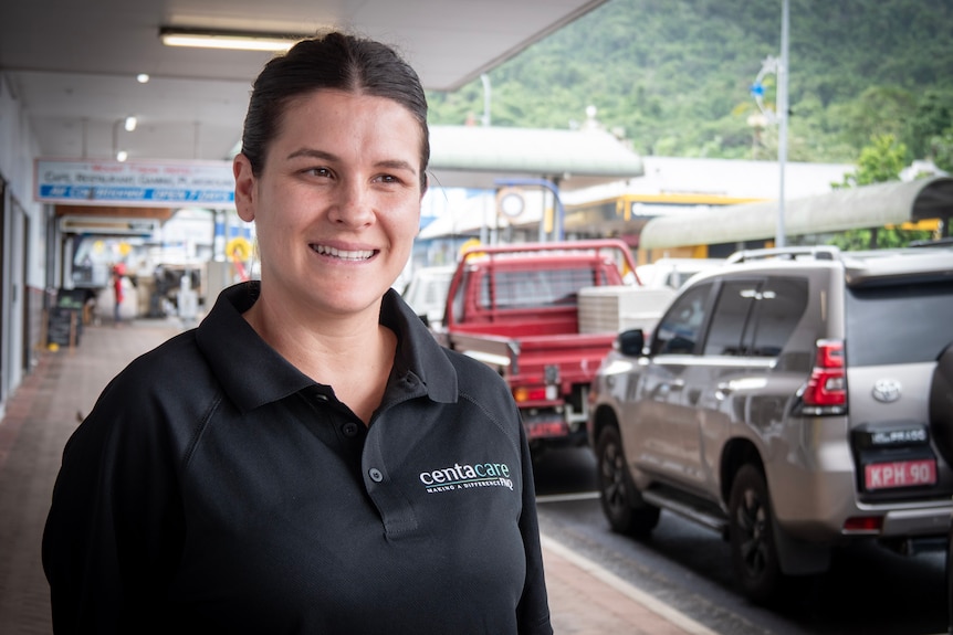 A smiling young woman, Reegan, stands on the shopping strip of a country city.