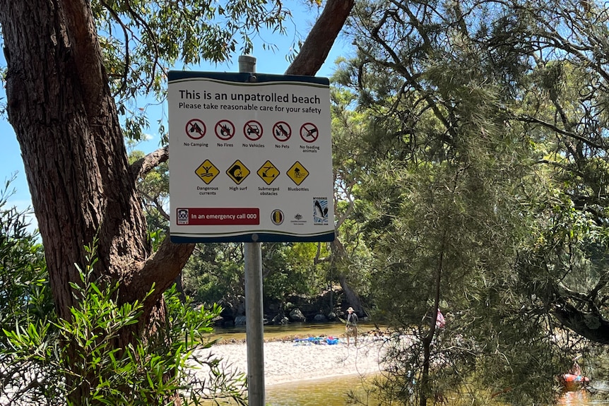 a sign that explains to beachgoers that there are no lifeguards on duty.