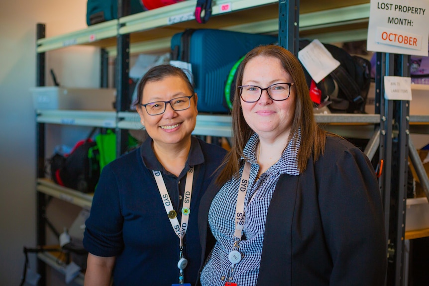 Two women in a lost property storage unit.