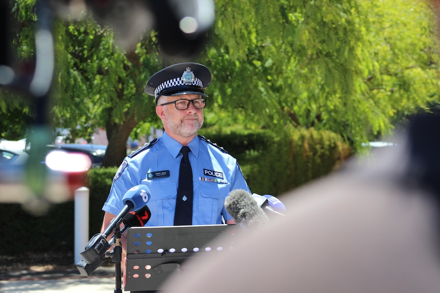 A man dressed in police uniform behind a lectern 