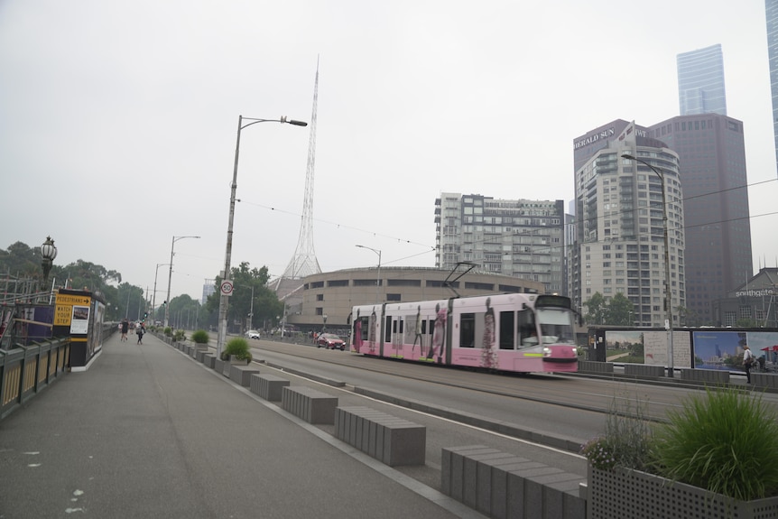 A tram travels through a hazy victoria
