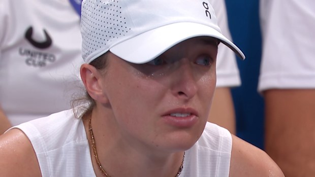 A visibly emotional Iga Swiatek wipes away tears.