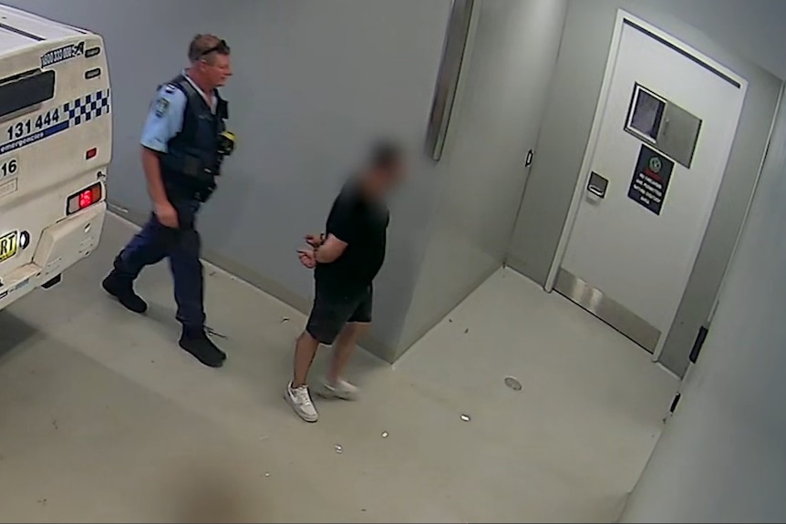 Man in dark shirt and shorts with blurred face with police officer behind.