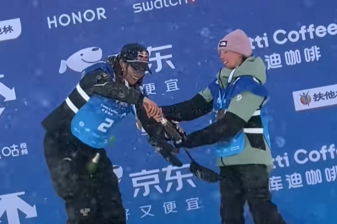 Eileen Gu helps Indra Brown with her champagne