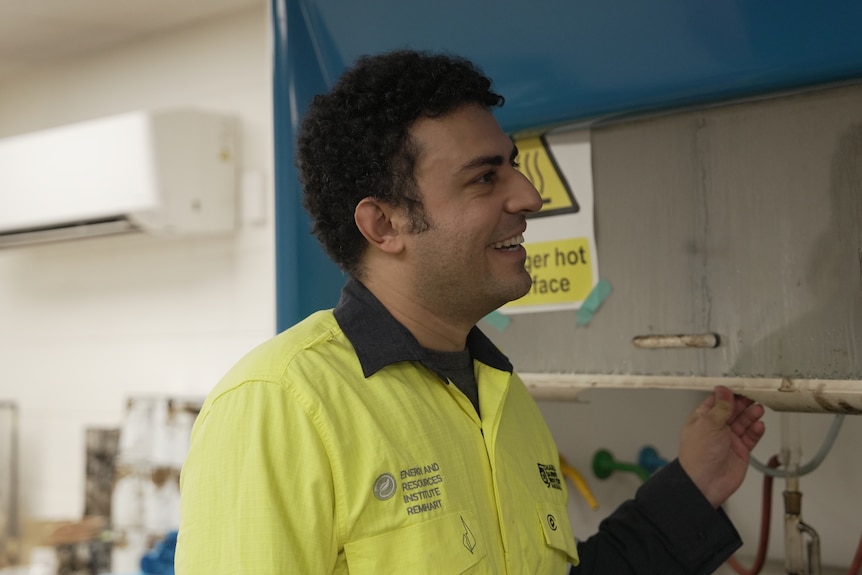 A man standing in an industrial workshop, wearing a shirt with the CDU logo.