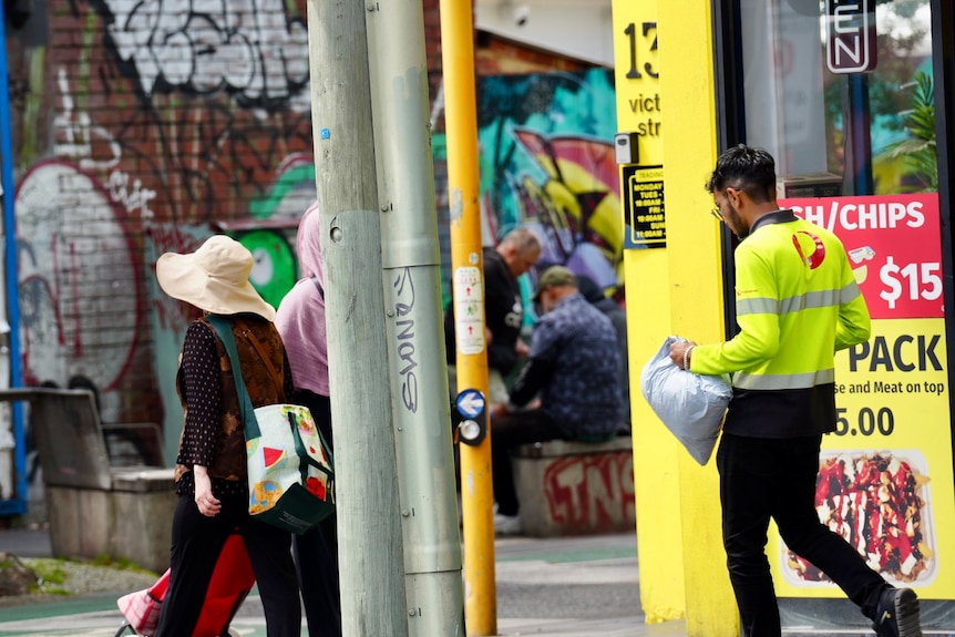 People sitting on the corner of Victoria and Lennox streets