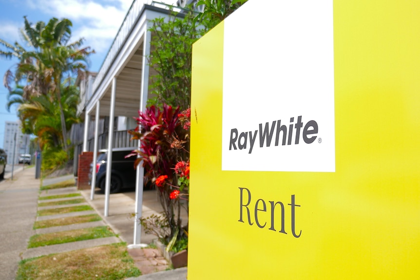 a close of up a for rent sign in front of a house
