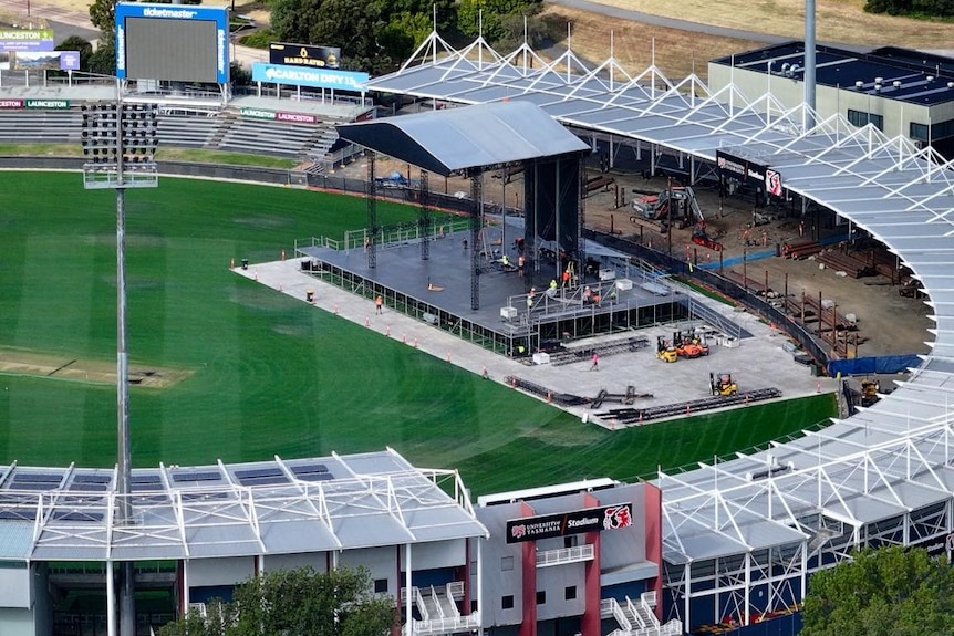 Stage under construction for rock concert in sports oval.