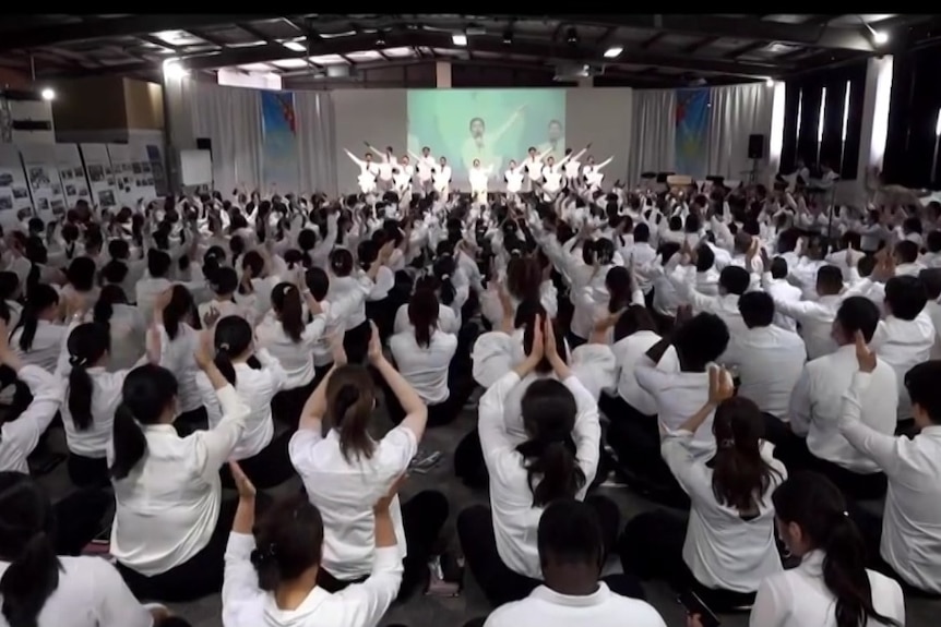 A large group of people watching a religious performance