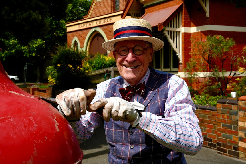 Mick Slocum scraping a pillar box in Albert Park, Victoria