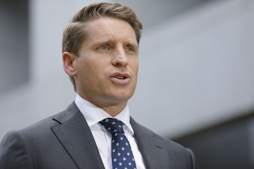 A fair-haired man in a suit and tie.