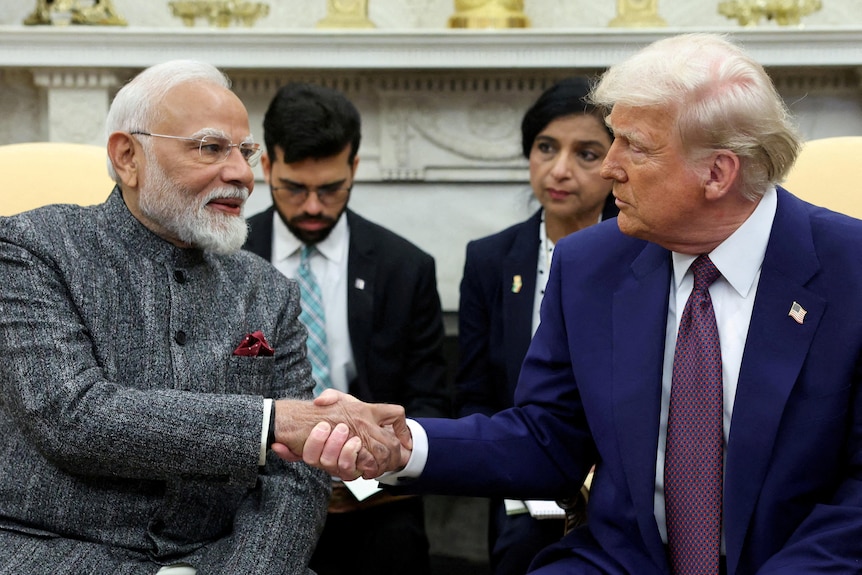 Two men shake hands.