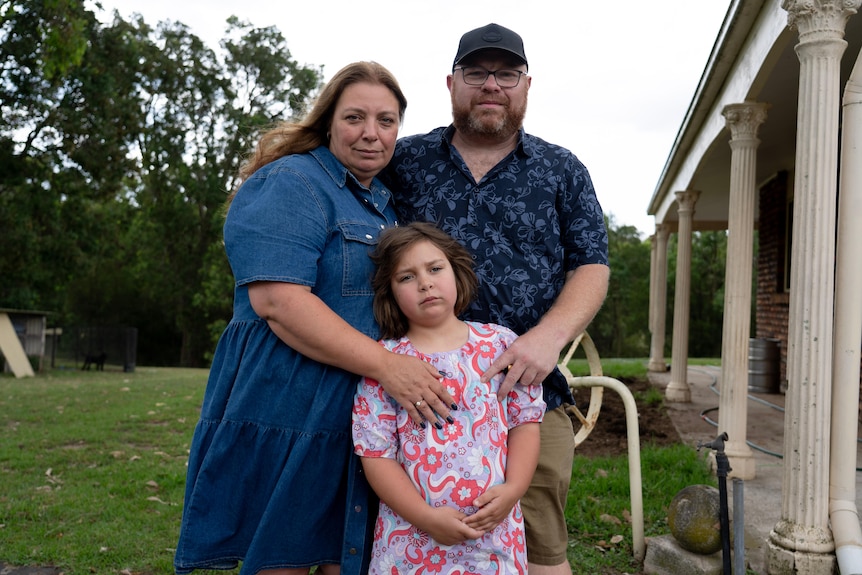 Woman and man standing with child