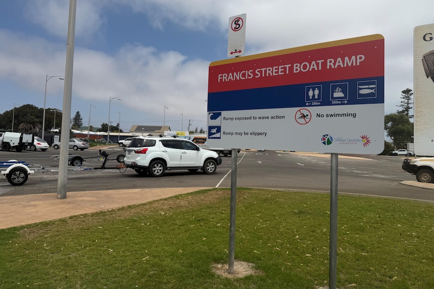 Sign saying francis street boat ramp. Car and boat trailer in background.