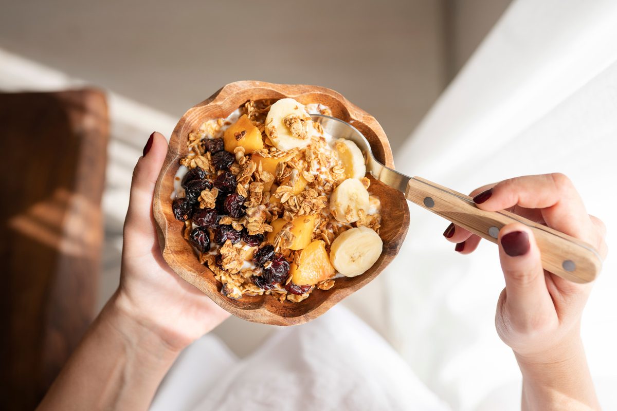 Photo of a bowl full of granola, fruit and porridge.
