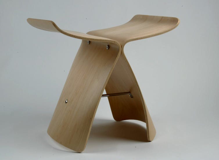 A stool made with two curved pieces of wood, against a white background.