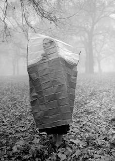 A woman wearing a cape to protect from smog