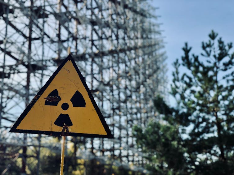 a yellow triangular sign with a nuclear symbol.