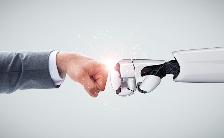 Fist bump between human and robotic fists.