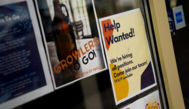 FILE PHOTO: An employee hiring sign is seen in a window of a business in Arlington