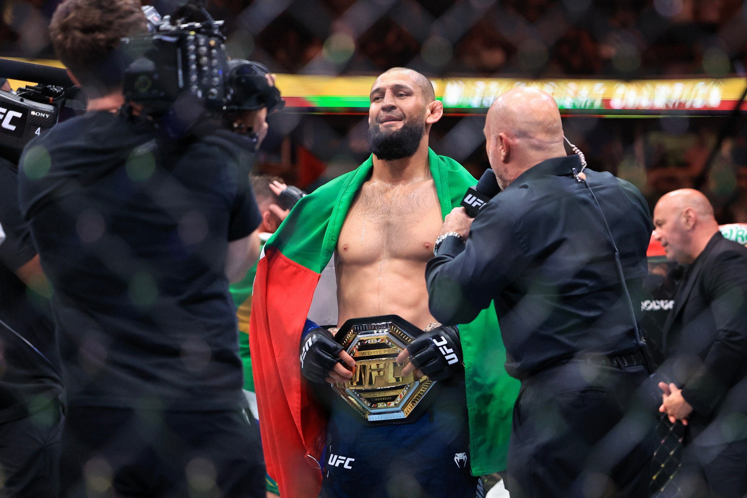 CHICAGO, ILLINOIS - AUGUST 16: Joe Rogan talks to Khamzat Chimaev of the United Arab Emirates after his middleweight title bout victory in UFC 319 at the United Center on August 16, 2025 in Chicago, Illinois. (Photo by Geoff Stellfox/Getty Images)