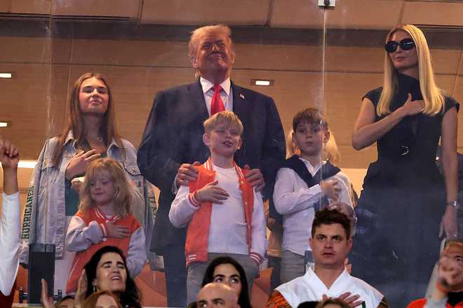 MIAMI GARDENS, FLORIDA - JANUARY 19: U.S. President Donald Trump stands for the National Anthem with his family prior to a game between the Miami Hurricanes and the Indiana Hoosiers in the 2026 College Football Playoff National Championship at Hard Rock Stadium on January 19, 2026 in Miami Gardens, Florida.  (Photo by Alex Slitz/Getty Images)