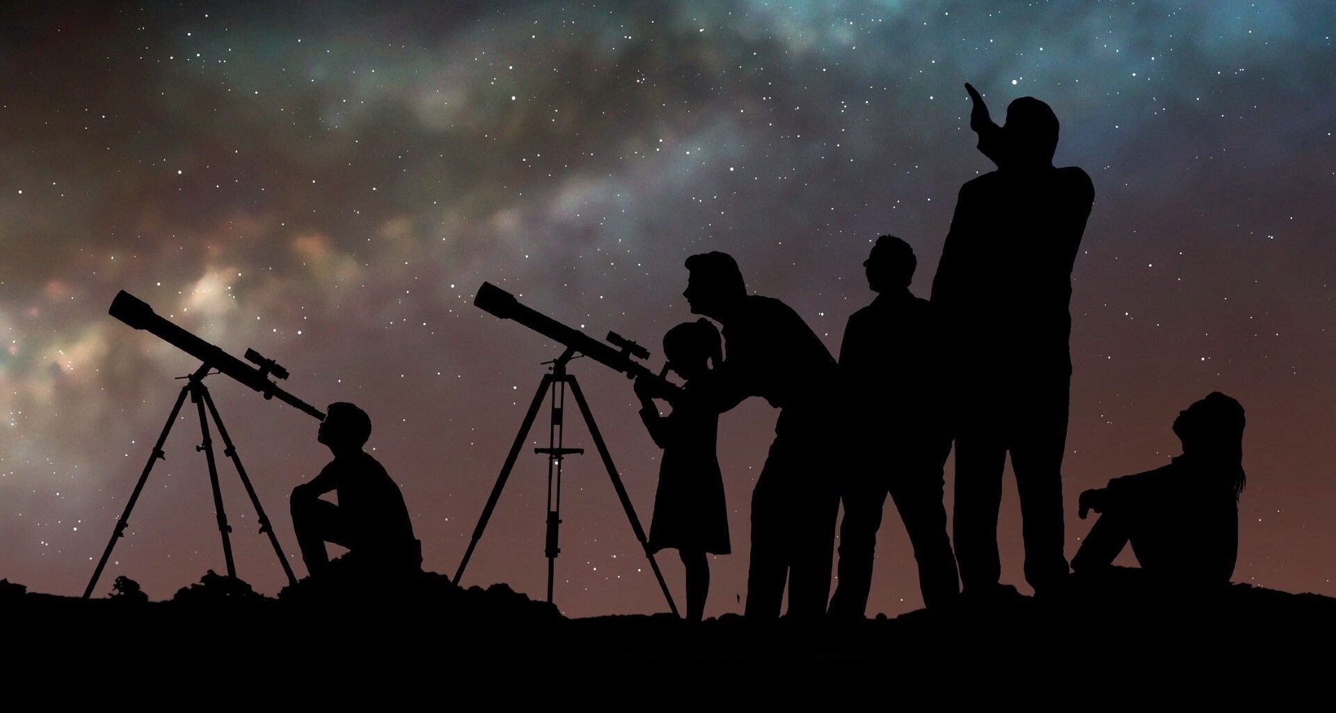 A group of people look up at the night sky through telescopes.