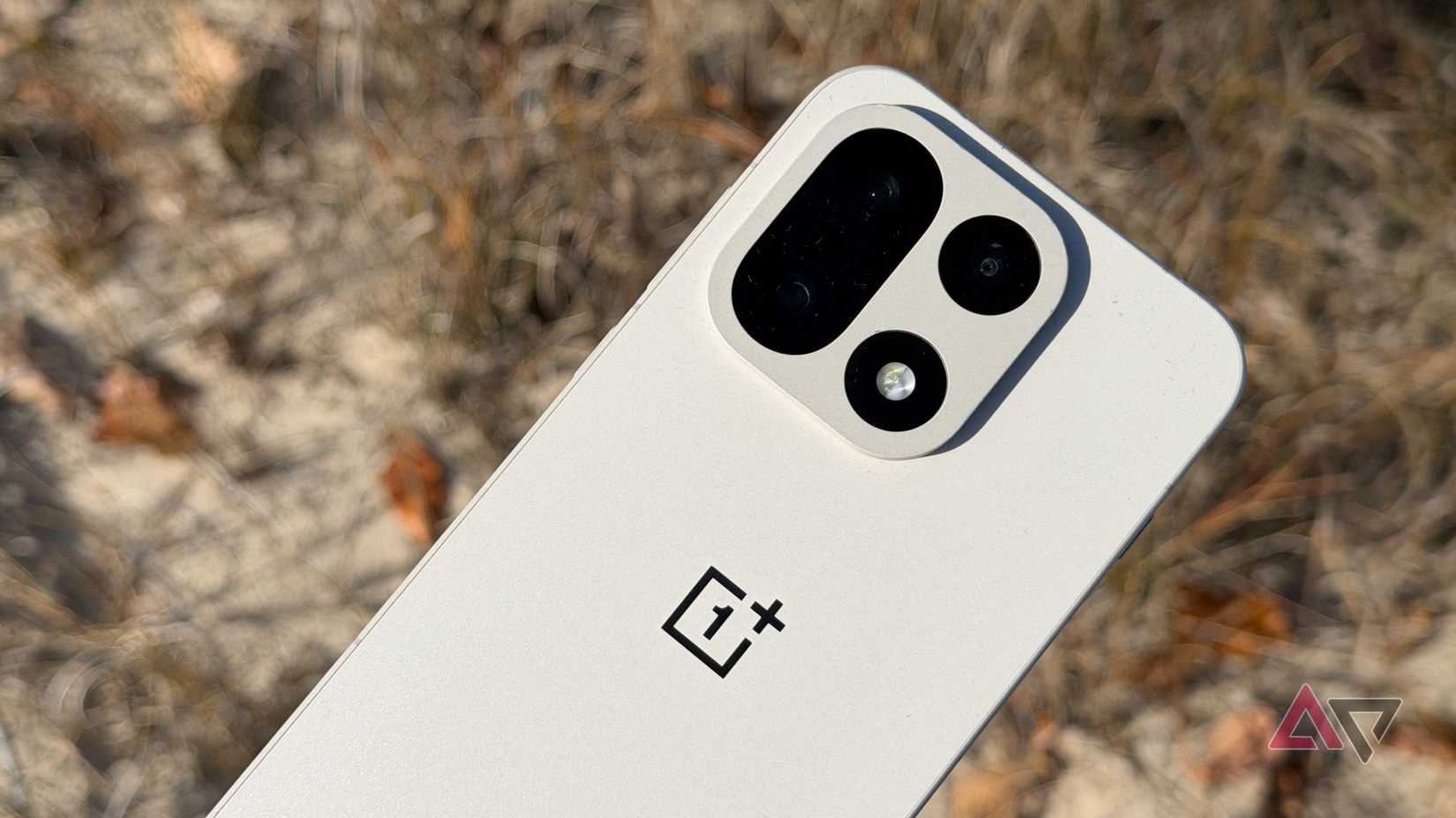 OnePlus 15 displayed against sand