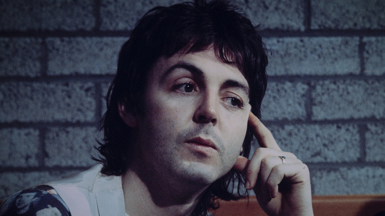 Paul McCartney thinking with finger on temple in 1976