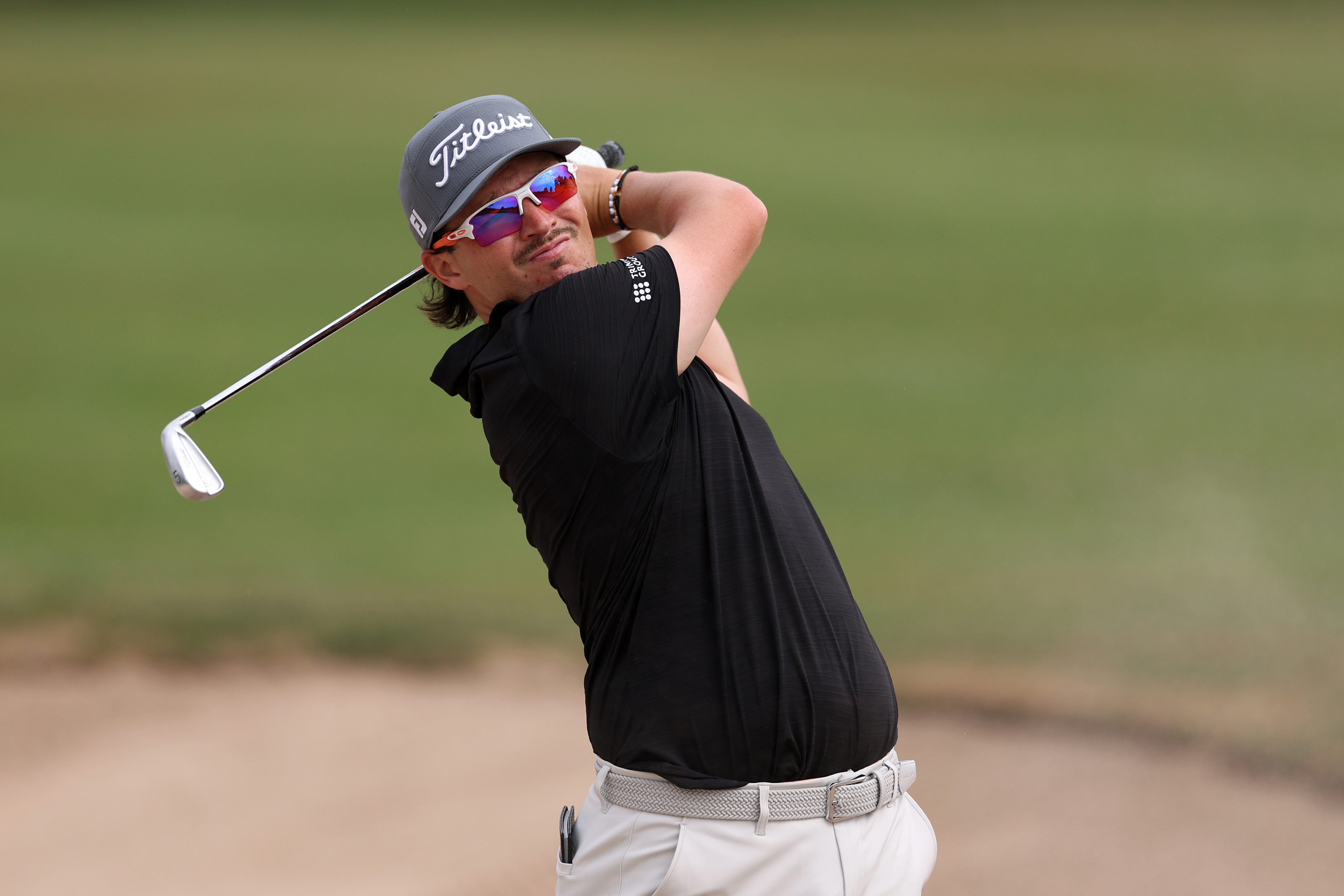 Ewen Ferguson hits an iron shot from the fairway