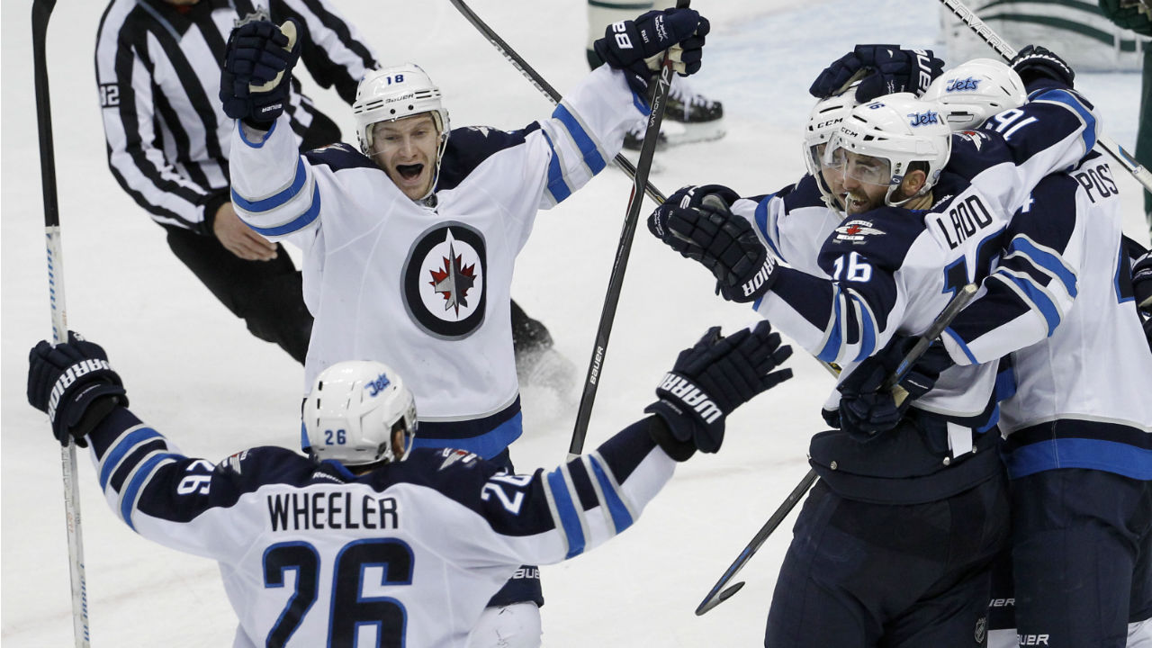 Winnipeg Jets center Bryan Little, center, and right wing Blake Wheeler celebrate with left wing Andrew Ladd and other teammates after Ladd's game-winning goal against Minnesota Wild goalie John Curry during overtime on Saturday. (Ann Heisenfelt/AP)