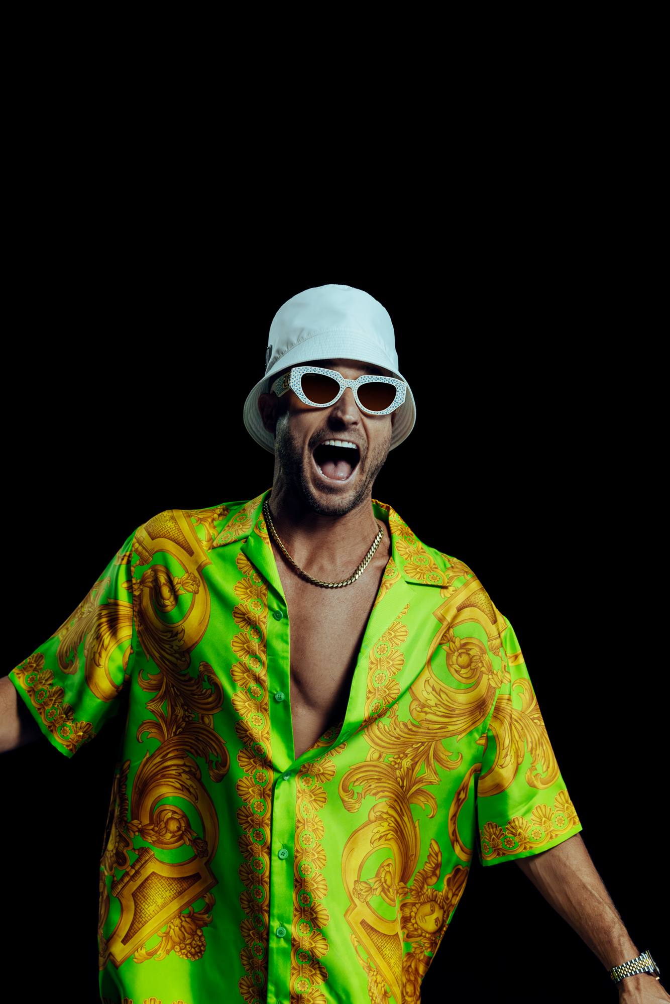 man in bucket hat and sunglasses wearing colourful shirt with mouth wide open