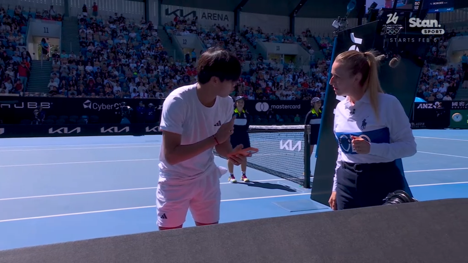 Learner Tien speaks to the umpire while putting his phone in his bag.