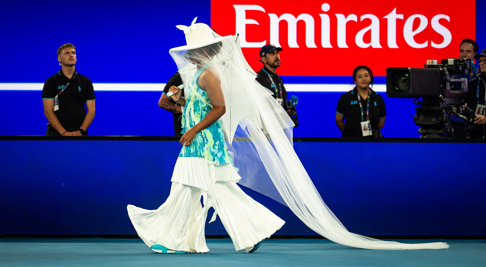 naomi osaka dressed in flowy gown walks on to tennis court