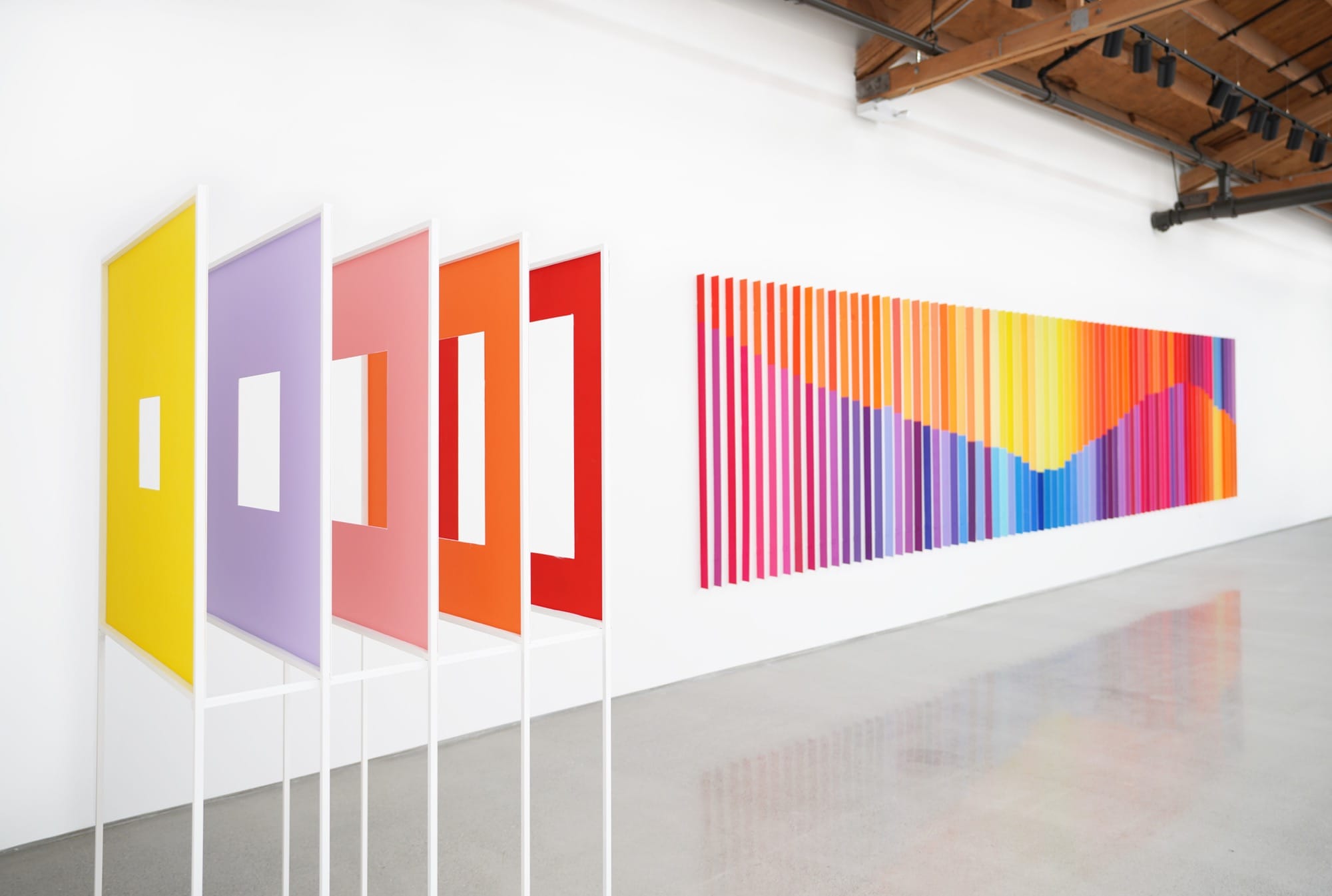 a standing sculpture and wall installation in vivid color by Luftwerk