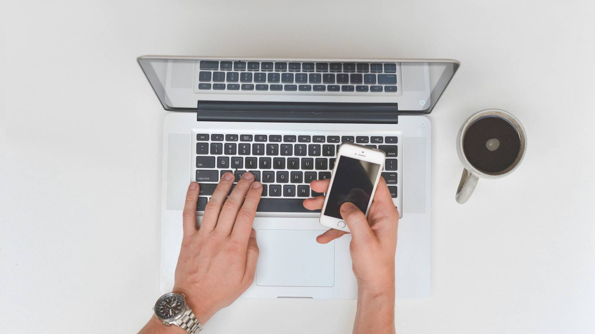 A person typing while holding an iPhone