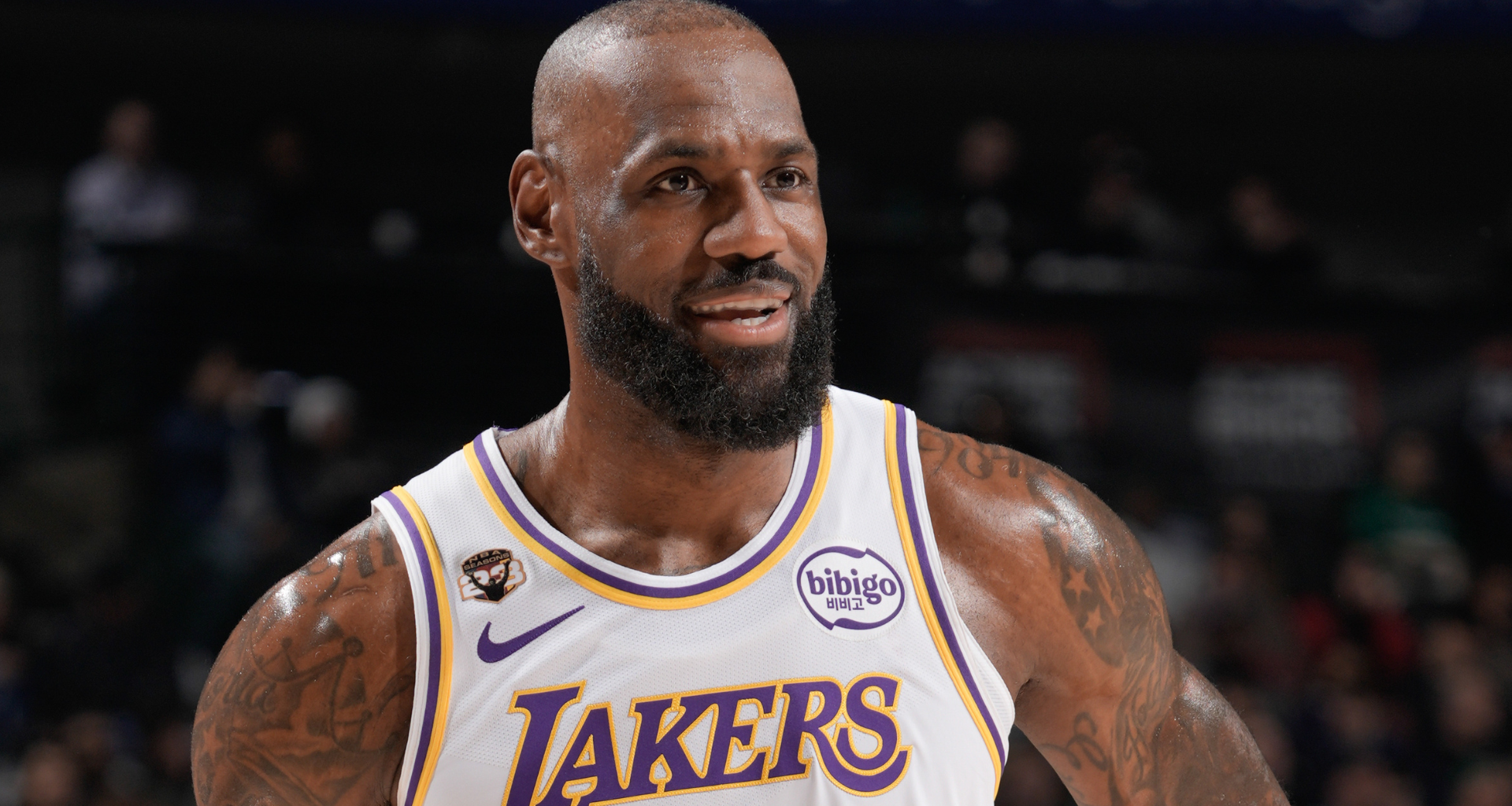 LeBron James in a Lakers jersey, smiling on a basketball court.