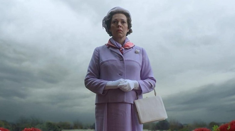 Olivia Colman's Queen Elizabeth II wearing purple clothes and hat on The Crown