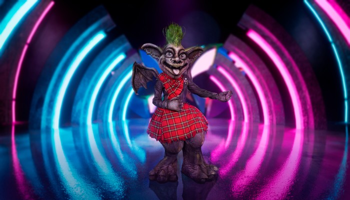 Someone dressed as a Gargoyle in red plaid clothing.