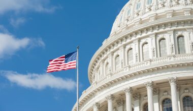 An American flag flying high next to the Capitol building in Washington, D.C.