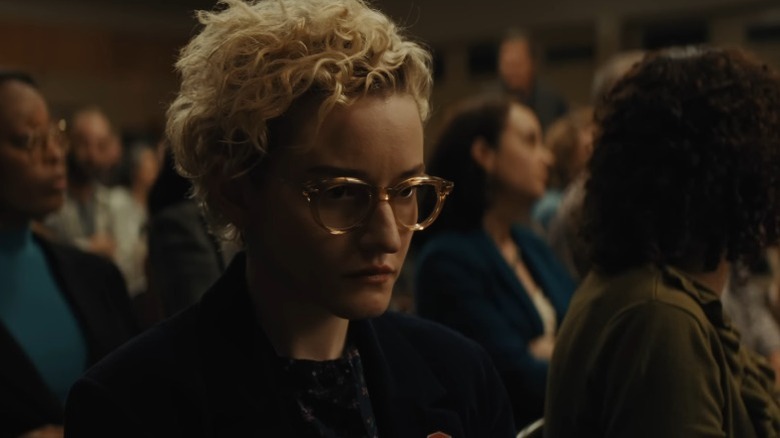 Julia Garner as Justine sitting in the audience of the school conference in Weapons