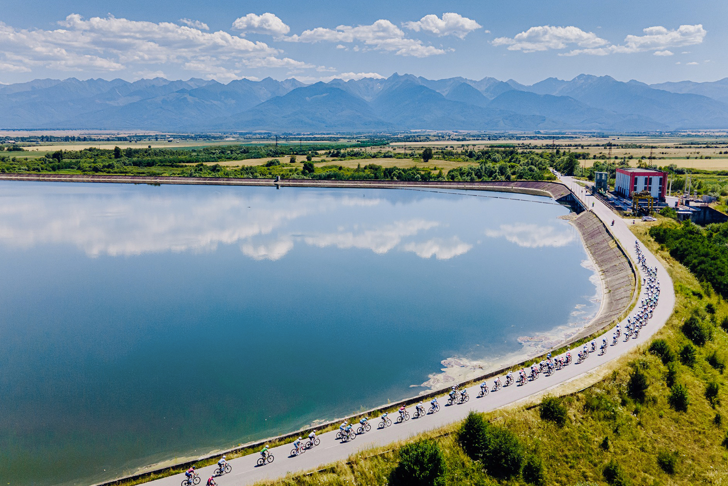 The peloton passes the River Olt on the road to the summit finish of B&acirc;lea Lac during the 2025 Sibiu Cycling Tour