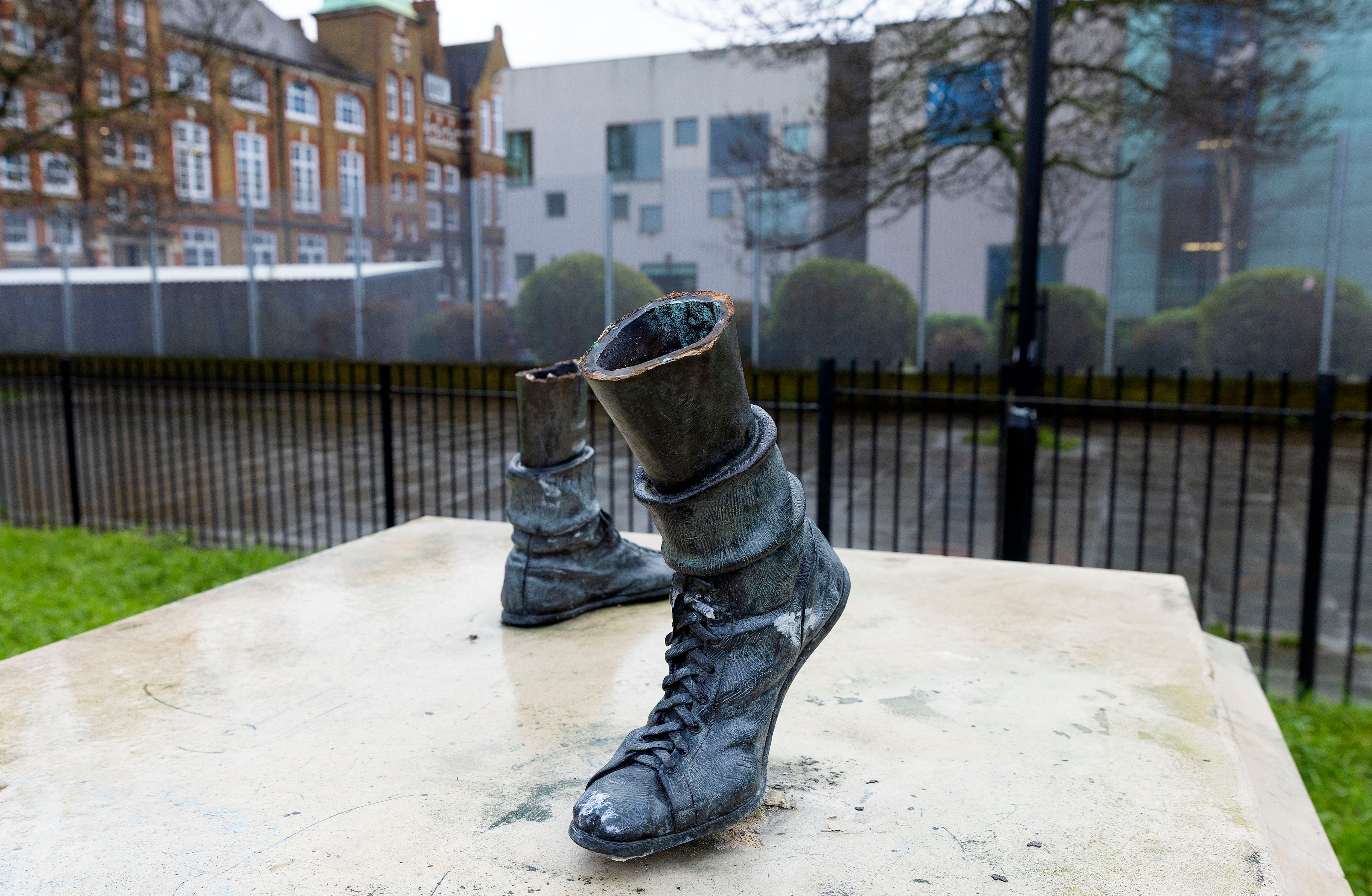 A statue of boxer Teddy Baldock with missing upper body, showing only his boxing boots on a pedestal.