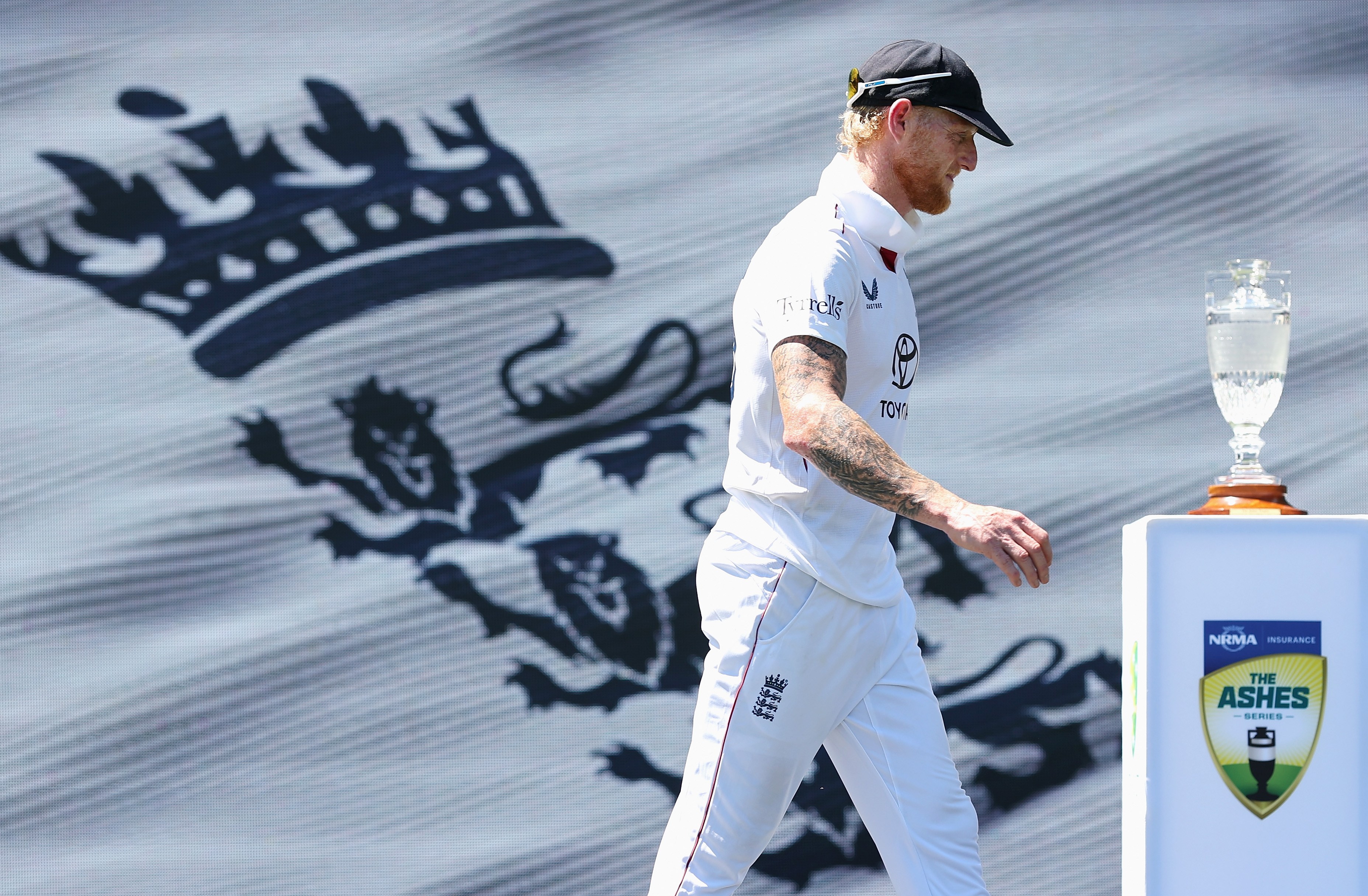 Ben Stokes of England walks past the Ashes trophy after England's defeat.