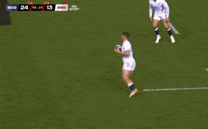 Rugby player with the ball looking to pass.