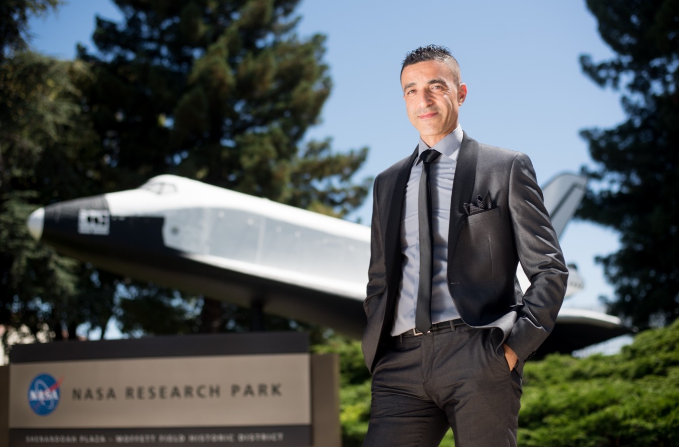 Fathi Karouia standing in front of a space shuttle at NASA Research Park.