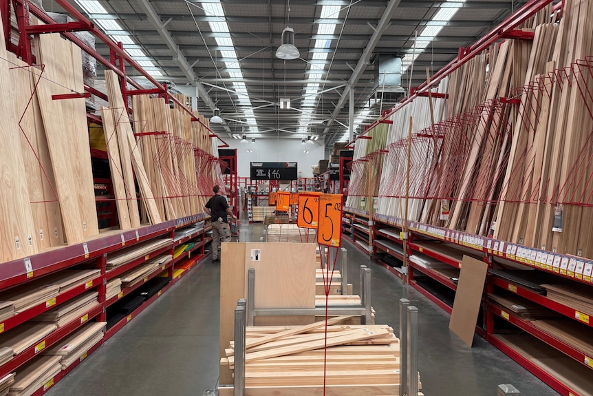 Piles of timber stacked upright on either side of an aisle, with small flat stacks in the middle, at Bunnings hardware store
